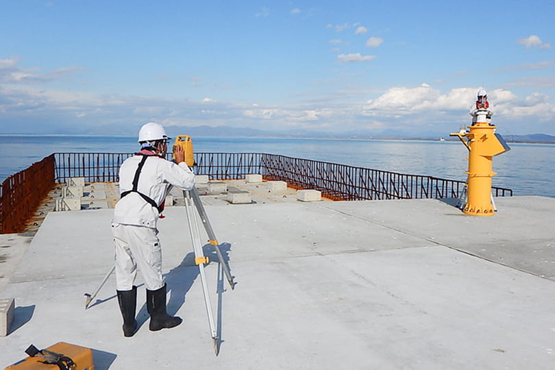 トータルステーション（TS）による測量中の写真